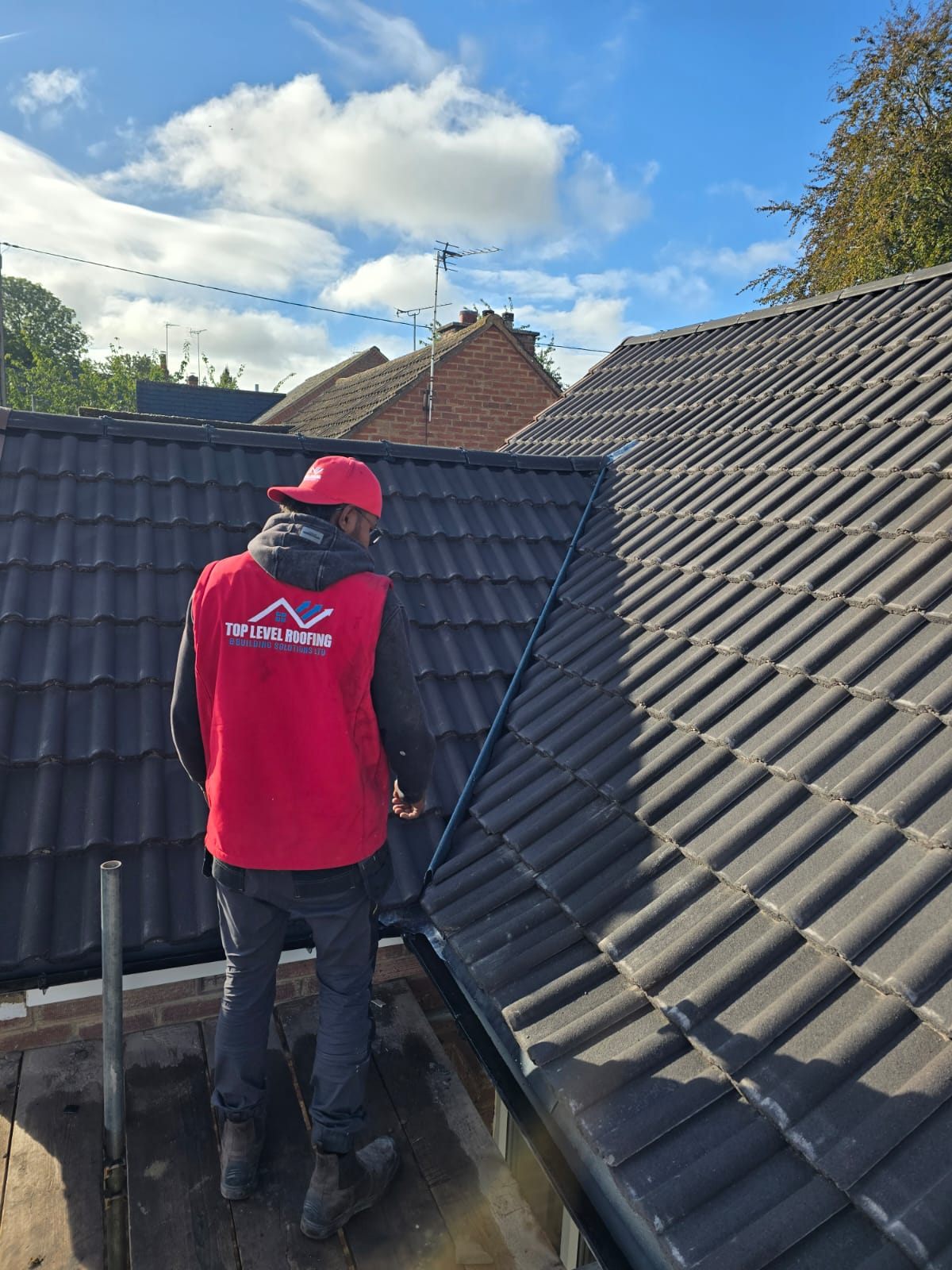 A Top Level Roofing team member inspecting a new tiled roof