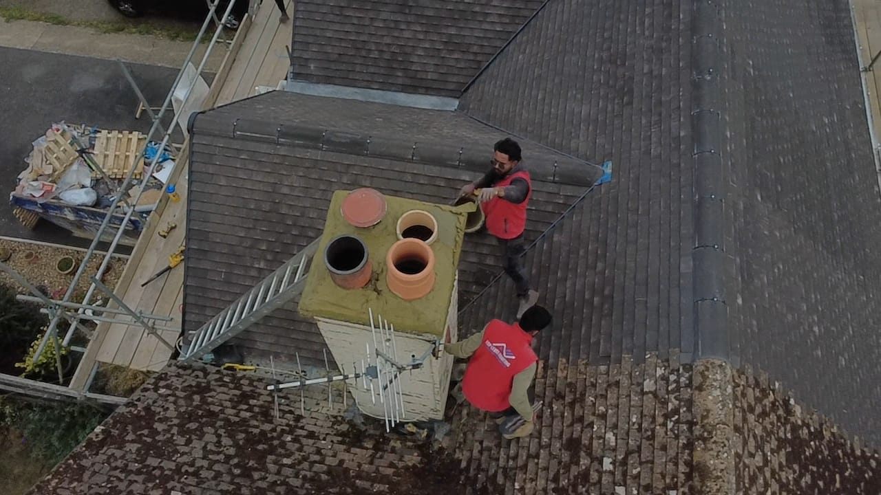 Aerial view of roofers rebuilding a multi-pot chimney stack by Top Level Roofing & Building Solutions