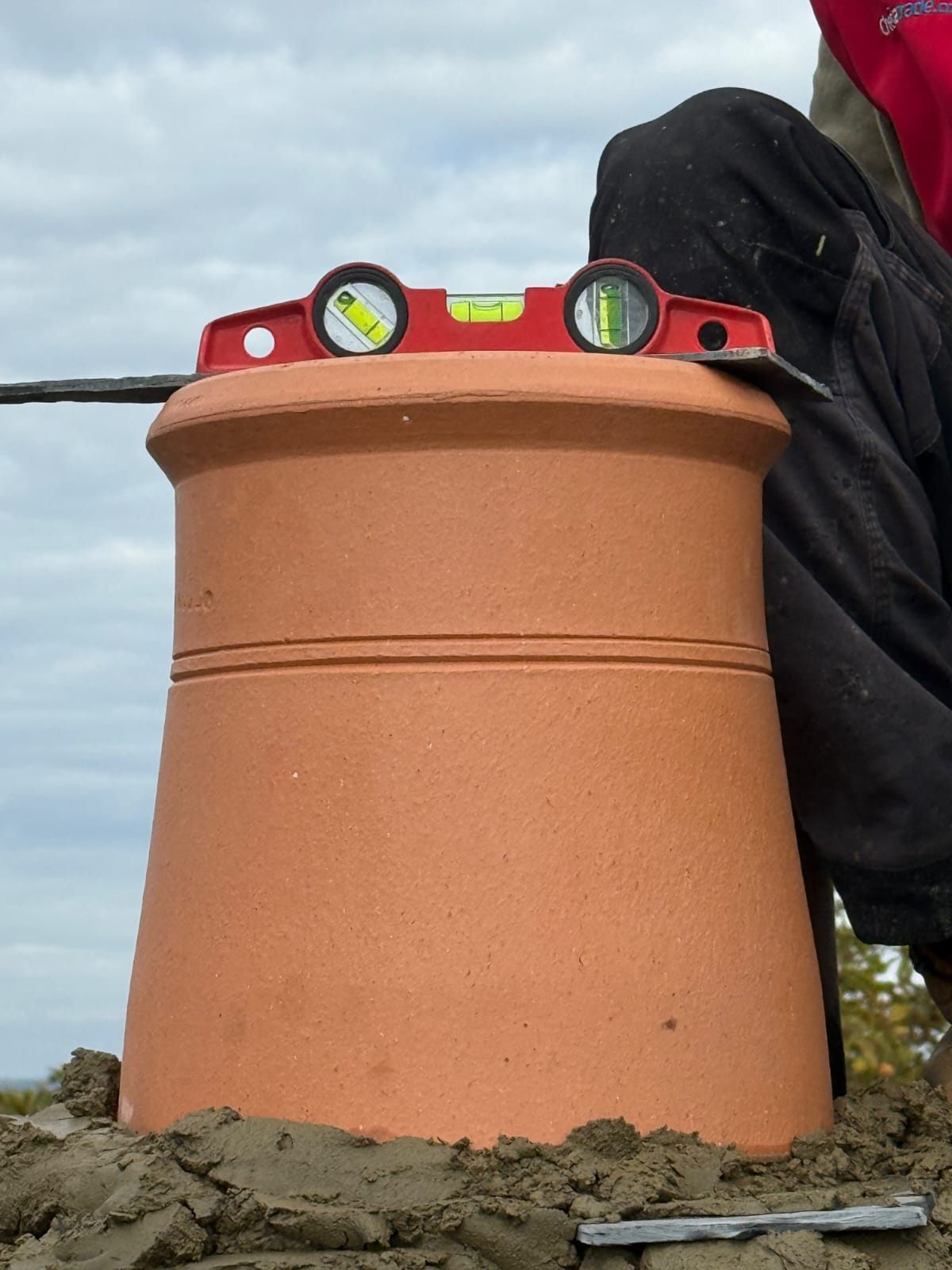 A new terracotta chimney pot levelled on fresh mortar by Top Level Roofing & Building Solutions
