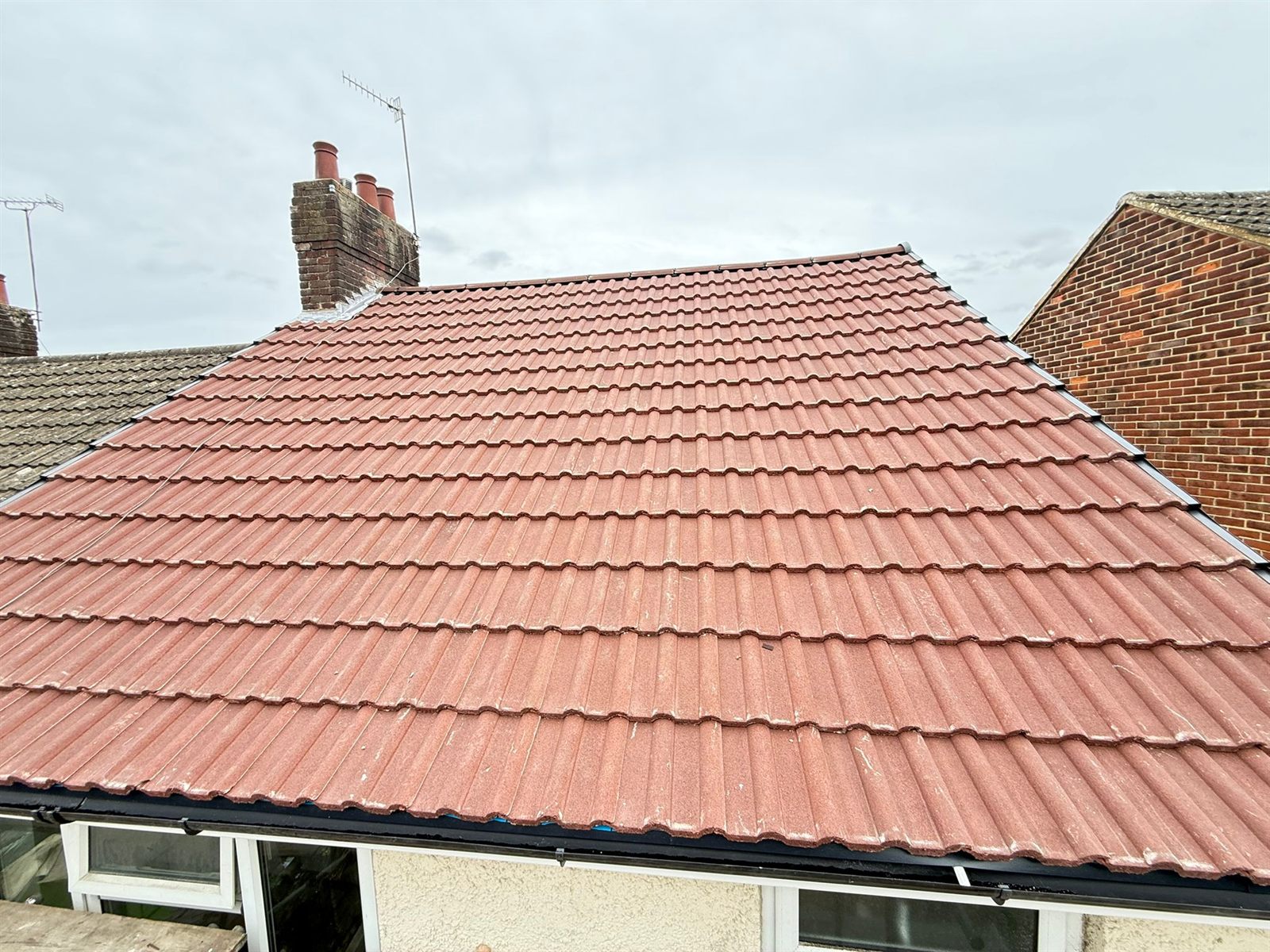 A finished red tiled roof with chimney stacks by Top Level Roofing & Building Solutions