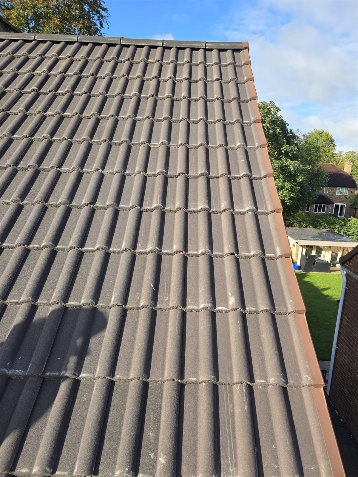 A completed tiled pitched roof under a blue sky by Top Level Roofing & Building Solutions